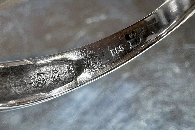 Close-up of hallmarks inside the band of a white gold ring