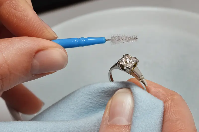 Reinigung eines Diamantringes mithilfe von Seifenlauge und Bürstchen