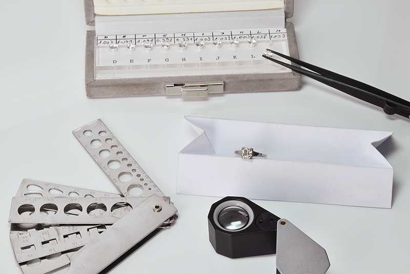 Professionelle Utensilien für die Graduierung von Diamanten auf weißem Grund
