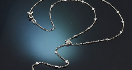 Weißgoldenes Y-Collier mit Diamanten auf schwarzem Grund liegend