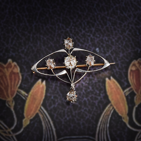 historische Diamantbrosche liegt auf einem dunklen floralen Muster